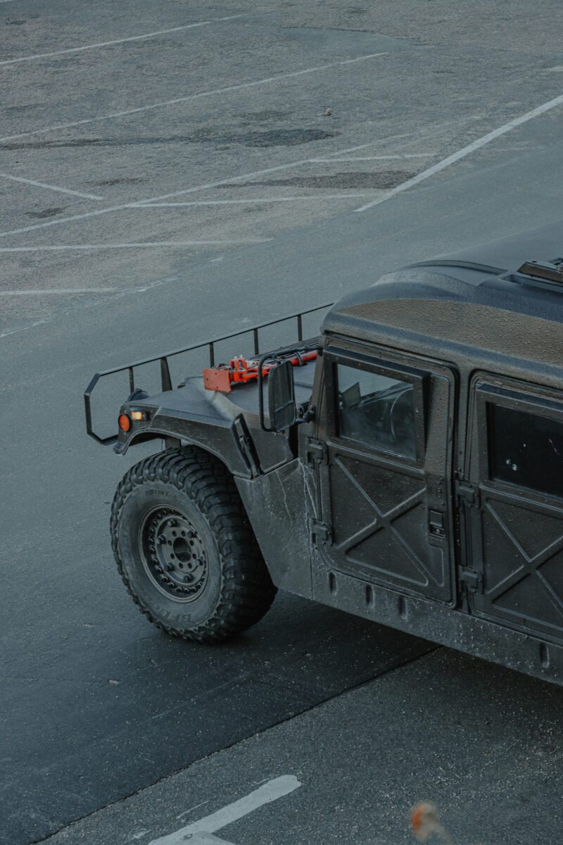 A high angle shot of a rugged military hummer vehicle on an empty asphalt road.