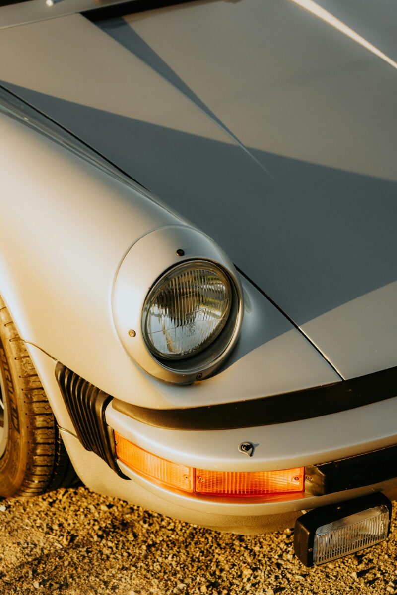 Classic cars on lifts in a French auto repair shop, showcasing vintage automobile restoration.